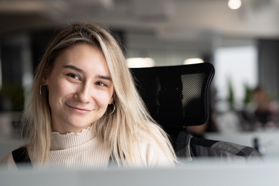 Employee using desk booking app on tablet to reserve workspace in hybrid office