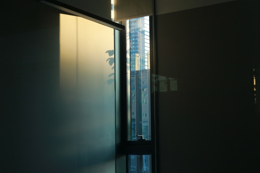 Digital signage LCD display mounted on an office wall showing scheduled content